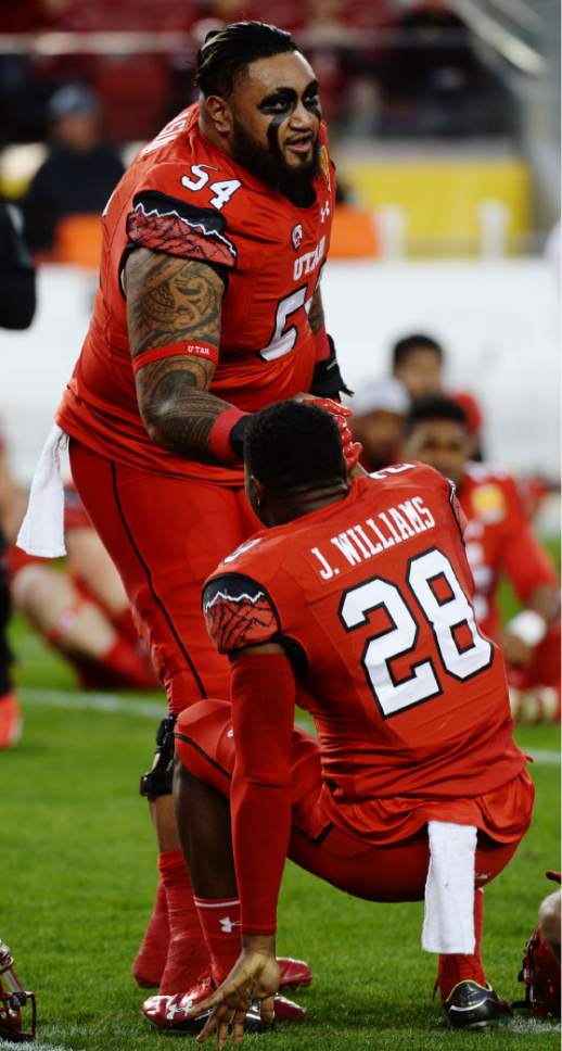 Steve Griffin / The Salt Lake Tribune

Utah Utes offensive lineman Isaac Asiata (54)helps Utah Utes running back Joe Williams (28) up after the Utes warmed up prior to the start of the Foster Farms Bowl at Levi's Stadium in Santa Clara California  Wednesday December 28, 2016.