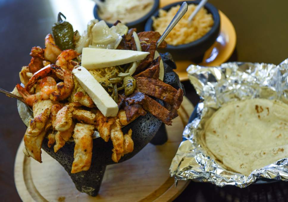 Francisco Kjolseth | The Salt Lake Tribune
The family-sized Molcajete from Los Molcajetes in West Valley City. The signature dish is an overflowing lava rock filled full of a delicious green tomatillo sauce, melted cheese, chicken, steak, cactus, roasted chiles and shrimp and a side of tortillas, rice and beans.