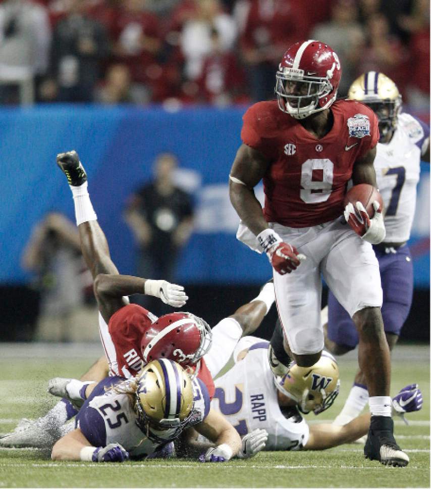 Alabama running back Bo Scarbrough (9) runs the ball against Washington defensive back Jordan Miller (23) during the second half of the Peach Bowl NCAA college football playoff game, Saturday, Dec. 31, 2016, in Atlanta. Scarbrough scored a touchdown on the play. (AP Photo/Skip Martin)