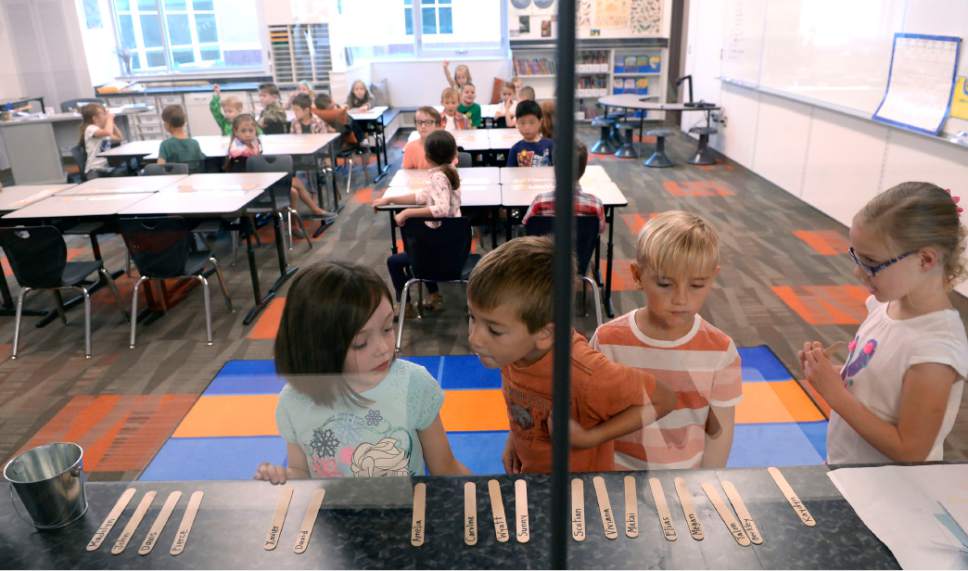 Al Hartmann  |  The Salt Lake Tribune
First graders in Jane Hart's class find their names on a stick and use it to select their choice of lunch by placing it in the correct bucket.  Today's choices were nachos with meat and cheese or chicken with potatos and gravy. Their choices are recorded and sent to the lunchroom where they can prepare for the rush of students at the brand new Butler Elementary in Cotonwood Heights Wenesday March 25.  It is one of hundreds of schools that opened Wednesday as students gear up for the 2016-2017 school year.