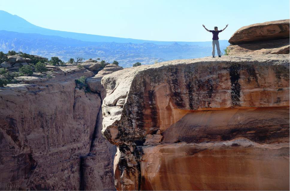 Scott Sommerdorf   |   Tribune  file photo
Interior Secretary Sally Jewell raises her arms in reaction to the view she saw as she looks out over a vista near the Gemini Bridges area, Thursday, July 14, 2016.
