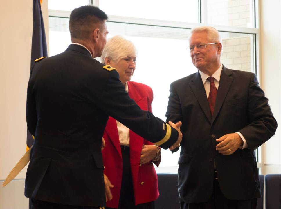 Rick Egan  |  The Salt Lake Tribune

Adjutant General. Maj. Gen. Jefferson Burton (left) stands next to Gail Miller (center) as he shakes hands with Bishop Dean Davies, LDS Church (right), at the ribbon-cutting ceremony for Sunrise Hall, a newly constructed worship center at Camp Williams. Friday, August 7, 2015.