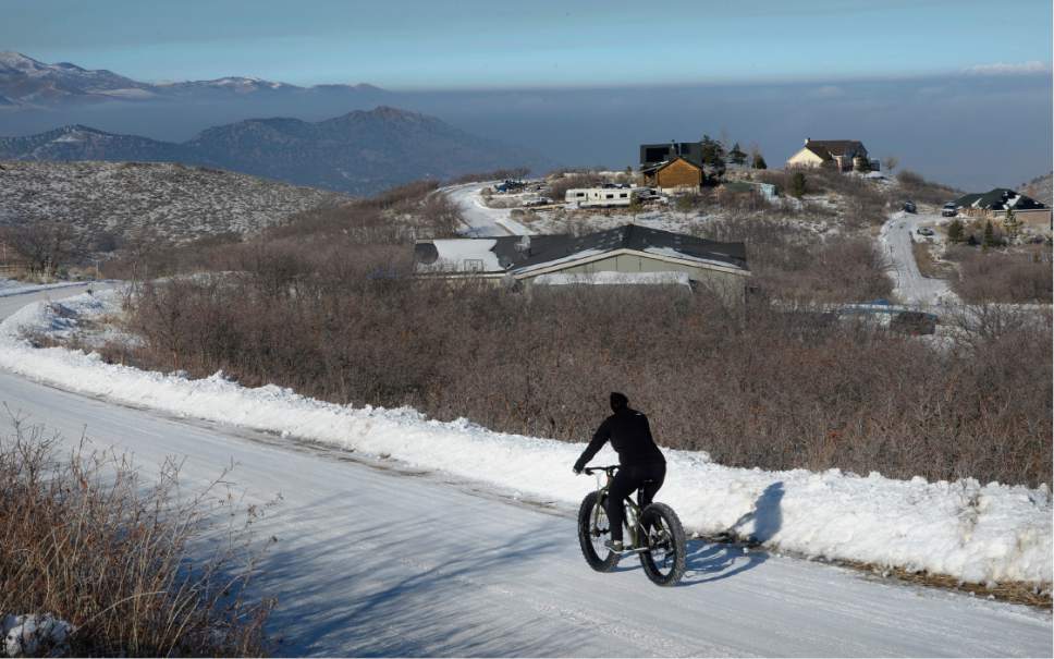 Scott Sommerdorf   |  The Salt Lake Tribune  
Elena Hall heads back home after a ride above the inversion that can be seen blanketing the Salt lake Valley from Rose Canyon near Herriman, Saturday, December 31, 2016.