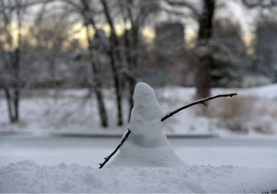 Al Hartmann  |  The Salt Lake Tribune
Miniature snowman in Liberty Park appears defeated as the sunrises over another snowy morning in downtown Salt Lake City Thursday Jan 5. Drivers endured a slow and go commute on snow-packed streets.