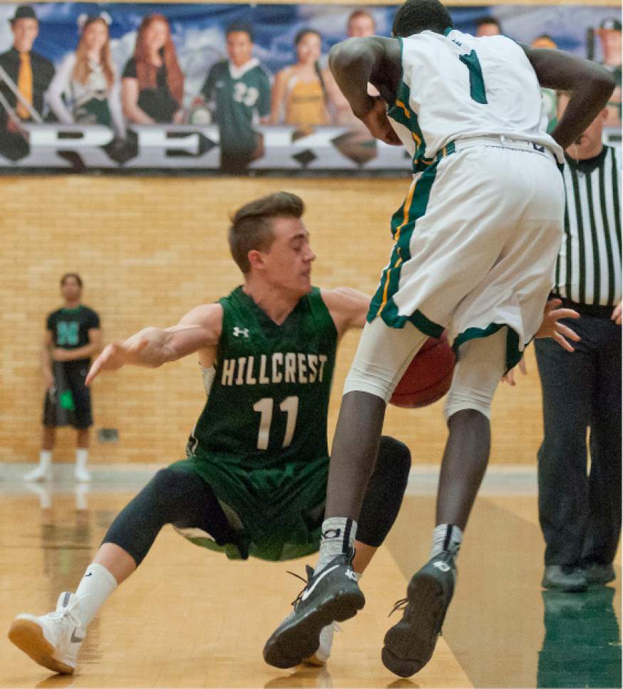 Michael Mangum  |  Special to the Tribune

Hillcrest Huskies senior Jaden Rogers (11) stumbles to the court as he battles for the ball with Kearns Cougars sophomore Majok Kuath (1) during their prep basketball game at Kearns High School in Salt Lake City on Tuesday, January 10, 2017. Kearns won 70-59.