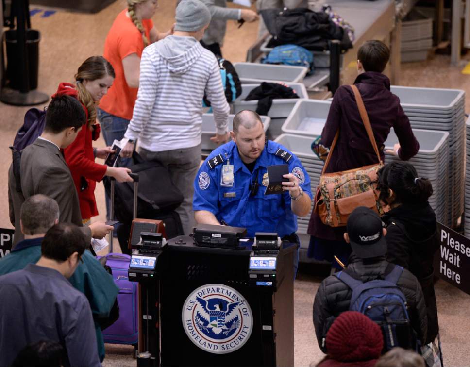 Al Hartmann  |  Tribune file photo
TSA worker checks identification and boarding passes before passengers have to remove jackets, belts, shoes, open laptops before going through the security scanners at Salt Lake International Airport Monday December 16, 2013.