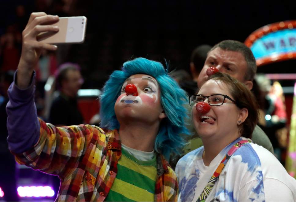 A Ringling Bros. and Barnum & Bailey clown takes a selfie with Jennifer and Kevin Fox, of Fort Pierce, Fla., during a pre show for fans Saturday, Jan. 14, 2017, in Orlando, Fla. The Ringling Bros. and Barnum & Bailey Circus will end the "The Greatest Show on Earth" in May, following a 146-year run of performances. Kenneth Feld, the chairman and CEO of Feld Entertainment, which owns the circus, told The Associated Press, declining attendance combined with high operating costs are among the reasons for closing. (AP Photo/Chris O'Meara)