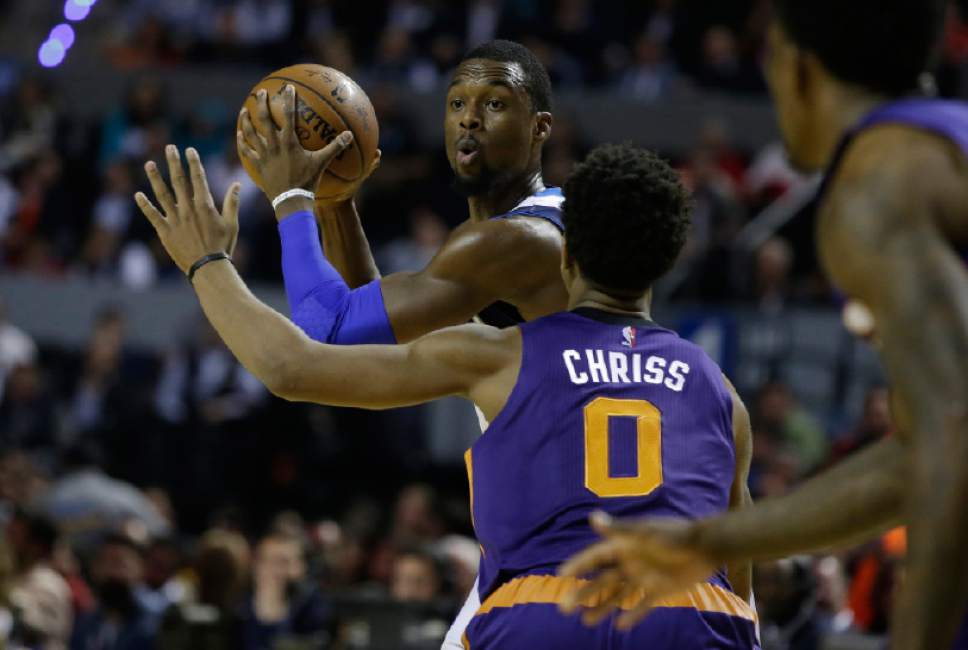 Dallas Mavericks Harrison Barnes looks to pass the ball as Phoenix Suns Marquese Chriss defends during the first half of their regular-season NBA basketball game in Mexico City, Thursday, Jan. 12, 2017. (AP Photo/Rebecca Blackwell)