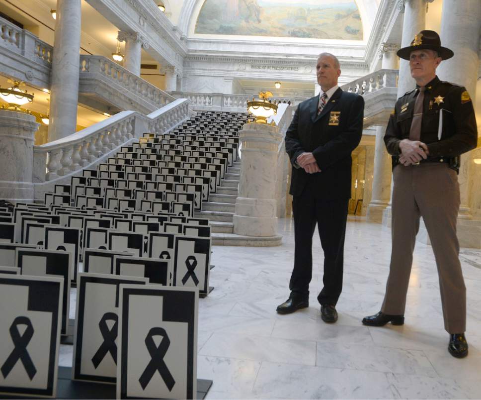 Al Hartmann  |  The Salt Lake Tribune 
Dept. of Public Safety Commissioner Keith Squires, left, and UHP Colonel Michael Rapich stand next to markers representing the 280 lives lost on Utah roads in 2016 placed on the stairway at the Utah State Capitol rotunda on Wednesday. It is a memorium to serve as a reminder to put safety first while driving.
