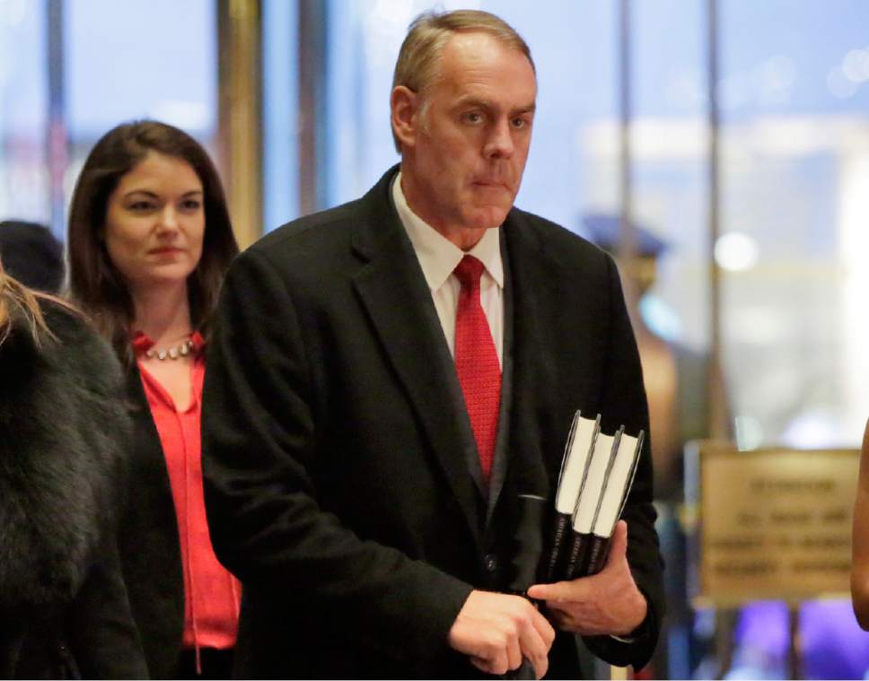 FILE - In this Dec. 12, 2016, file photo, Interior Secretary-designate Rep. Ryan Zinke, right, R-Mont., arrives in Trump Tower, in New York, Monday, Dec. 12, 2016. Zinke says he would never sell, give away or transfer public lands, a crucial stance in his home state of Montana and the West, where access to hunting and fishing is considered sacrosanct. (AP Photo/Richard Drew, File)