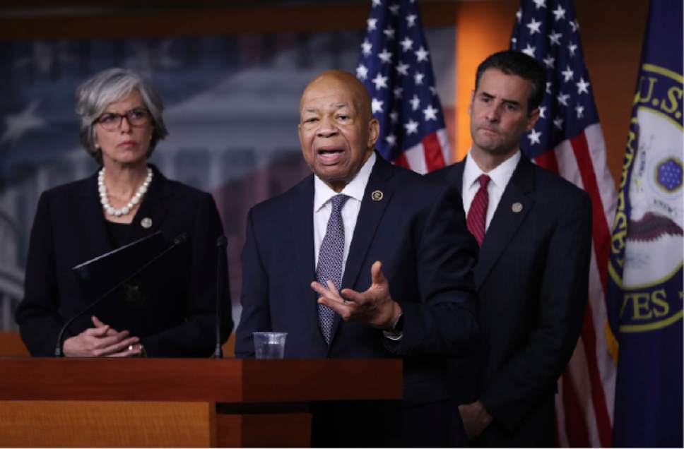 Rep. Elijah Cummings, D-Md., center, accompanied by Rep. John Sarbanes, D-Md., right, and Rep. Katherine Clark, D-Mass., speaks during a news conference on Capitol Hill in Washington, Thursday, Jan. 12, 2017 to discuss President-elect Donald Trump's conflicts of interest and ethical issues. (AP Photo/Manuel Balce Ceneta)