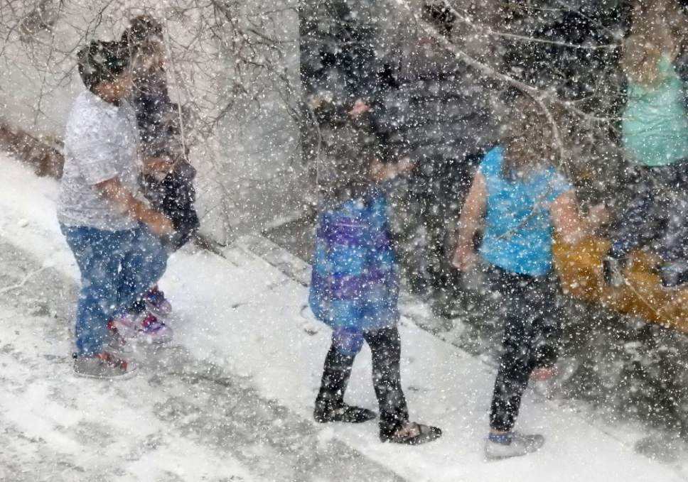 Al Hartmann  |  The Salt Lake Tribune
School children rush from the bus into the entrance of Clark Planeterium through falling snow Thursday Jan. 19 in Salt Lake City.  Stay turned for a few days of small storms.
