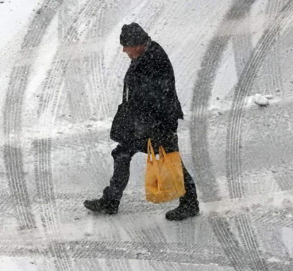 Al Hartmann  |  The Salt Lake Tribune
Pedestrian walks through snow falling Thursday Jan. 19 near the Gateway in Salt Lake City.  Stay turned for a few days of small storms.