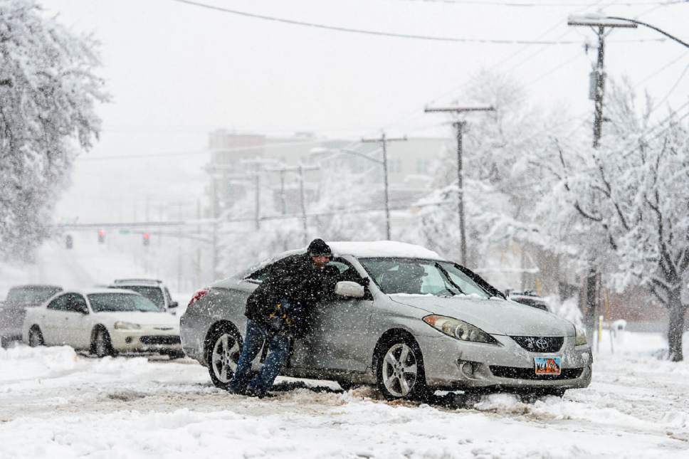 Trent Nelson  |  The Salt Lake Tribune
People work to get a car unstuck at South Temple and 400 East as a snowstorm hits Salt Lake City, Saturday January 21, 2017.