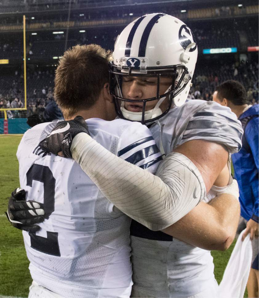 Rick Egan  |  The Salt Lake Tribune

Brigham Young Cougars defensive back Matt Hadley (2) gives Brigham Young Cougars defensive back Kai Nacua (12) a hugafter BYU defeated Wyoming 24-21in the Poinsettia Bowl, at Qualcomm Stadium in San Diego, December 21, 2016.
