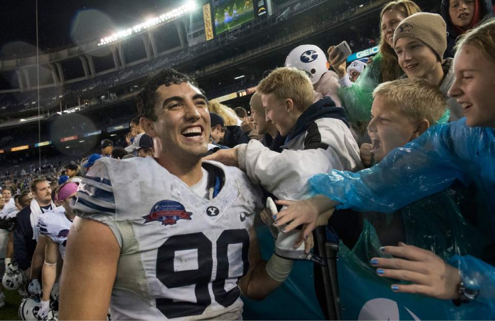 Rick Egan  |  The Salt Lake Tribune

Brigham Young Cougars offensive lineman Corbin Kaufusi (90) celebrates with fans, after BYU defeated Wyoming 24-21in the Poinsettia Bowl, at Qualcomm Stadium in San Diego, December 21, 2016.
