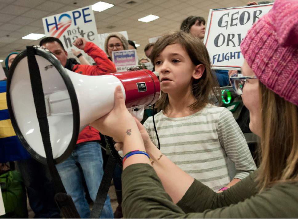 Michael Mangum  |  Special to the Tribune

Kathryn Jones-Porter holds a megaphone for Millie Kraatz, an 8 year old from Salt Lake City, as she speaks to the crowd and expresses her concerns during a protest at the Salt Lake City International Airport on Saturday, January 28, 2017. Hundreds gathered to protest President Trump's executive order on immigration, among many other social topics.