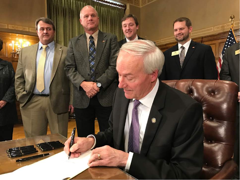 Arkansas Gov. Asa Hutchinson, signs into law legislation outlining a $50 million tax cut for thousands of low-income residents in Little Rock, Ark. A Senate panel endorsed a separate proposal aimed at forcing Amazon to collect state sales taxes, and lawmakers are eyeing the potential revenue from the move to help pay for future income tax cuts. (AP Photo by Andrew DeMillio)