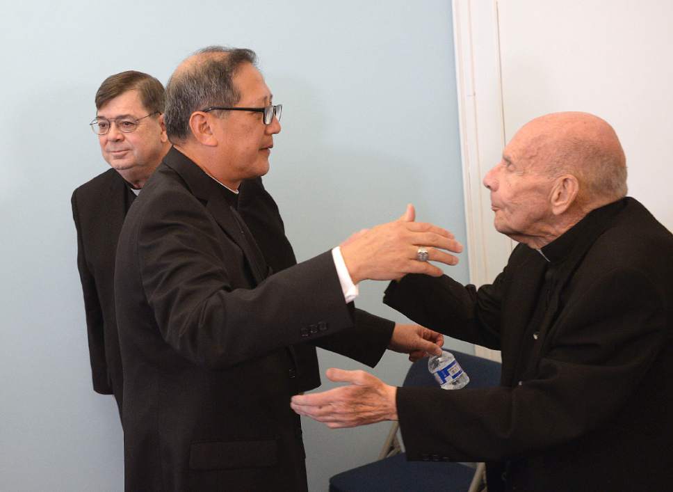 Al Hartmann  |  The Salt Lake Tribune 
Bishop elect Oscar Azarcon Solis, hugs Msgr. Terrence Fitzgerald, right, after introduced as the 10th Bishop of the Catholic Diocese of Salt Lake City Tuesday Jan. 10.  Msgr. Colin Bircumshaw, left.
