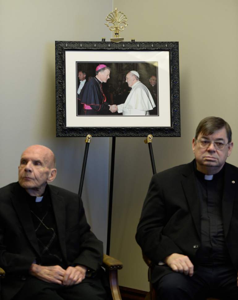 Francisco Kjolseth  |  The Salt Lake Tribune 
Monsignor J. Terrence Fitzgerald, left, and Colin F. Bircumshaw are seen alongside a picture of Utah's own Bishop John C Wester shaking hands with Pope Francis. The Vatican recently gave Bishop Wester an appointment to New Mexico.