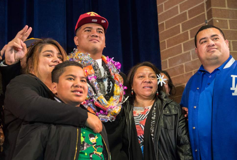 Leah Hogsten  |  The Salt Lake Tribune
Bingham High School senior football player Jay Tufele, center, poses for pictures with his sisters, brothers and  mother Salega and father Line Tufele, at right. Tufele, one of the most sought-after prep players in state history, announced Wednesday, February 1, 2017 during the school's college signing day that he will attend the University of Southern California to play for the Trojans in the fall.