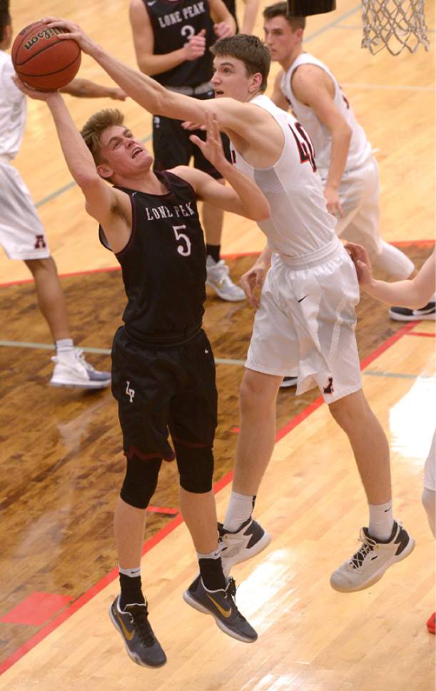 Leah Hogsten  |  The Salt Lake Tribune
American Fork's Isaac Johnson swats at Lone Peak's Max Brenchley. American Fork High School boys' basketball team leads Lone Peak High School 26-24 during their game Friday, February 3, 2017 in American Fork.
