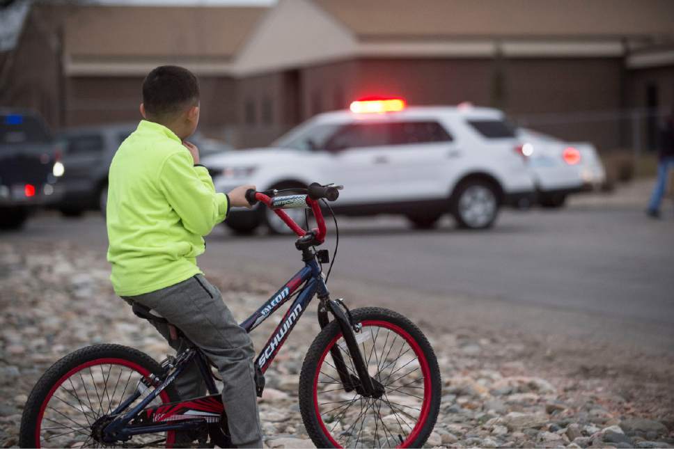Lennie Mahler  |  The Salt Lake Tribune

A boy watches as police secure American Preparatory Academy in West Valley City. Police investigated after reports of a man with a firearm Thursday, Feb. 9, 2017.