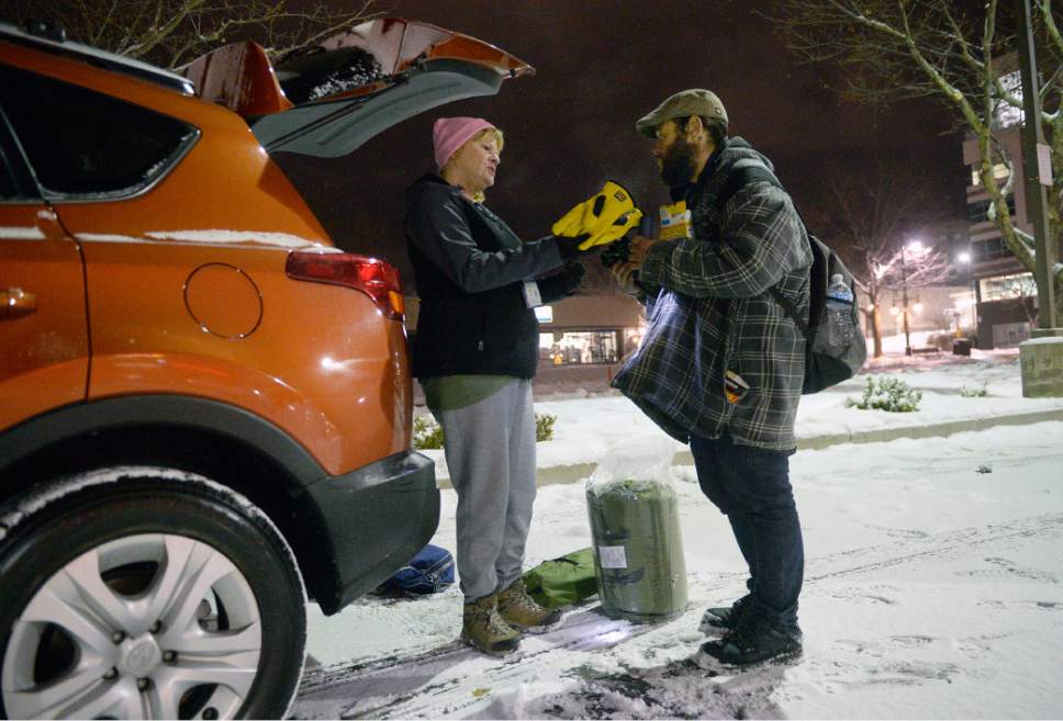 Al Hartmann  |  The Salt Lake Tribune
Volunteers set out at 4 a.m. Thursday Jan. 26 to search for homeless people on the streets for the Point-in-Time Homeless Count. Machele Nieto with the Homeless Outreach Team gives warm gloves, sleeping bag and winter clothing to homeless man Corey Wilkerson in a fast food restaurant parking lot in Sugarhouse. 
Volunteers of America partners with Utah State Community Services Office and the Salt Lake County conducted the annual survey to count unsheltered individuals suffering from homelessness.
