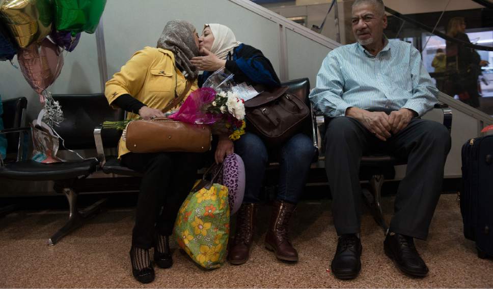 Leah Hogsten  |  The Salt Lake Tribune
l-r Iman Alsaadi and her Iraqi sister-in-law Nisreen Alsaadi kiss each other on the cheeks upon seeing each other for the first time in seven years at the Salt Lake International Airport, February 8, 2017. At right is Nisreen's brother, Qays Eabd Aljalil. Nisreen Alsaadi and her son Zaid Alsaadi were allowed to come to the U.S. after a judge on Friday temporarily blocked President Donald Trump's ban on people from seven predominantly Muslim countries from entering the United States.