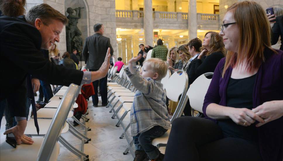 Al Hartmann  |  The Salt Lake Tribune
Sen. Todd Weiler, R-Woods Cross, gives a high five to 2-year-old Tobias Moore at a housing rally in the Capitol rotunda Thursday Feb 9.  Weiler and Rep. Becky Edwards, R-North Salt Lake, are sponsoring HB36 to help get more affordable housing, whether for sale or rent, onto the market quickly.  Tobias' mother Krista Moore, right, is a nurse who lives in West Jordan and recently took in a homeless family of five into her home.  She understands the need for getting people into affordable housing and supports the bill.