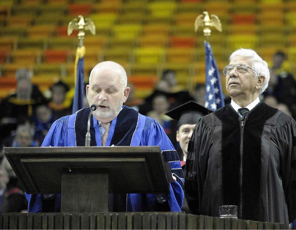 Douglas S. Foxley, left, reads a citation to Dominic A. Welch, right, as he is awarded an honorary Doctor of Humane Letters during commencement at Utah State University in Logan Saturday. Welch, a 1957 graduate of USU, is a former publisher of the Salt Lake Tribune who retired in August 2002. (Alan Murray/Herald Journal)