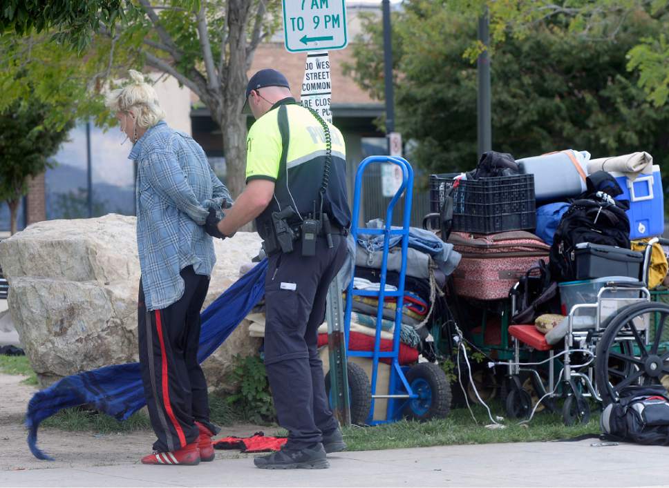Al Hartmann  |  Tribune file photo
Salt Lake City Police check identifications and made arrests in a sweep of the Rio Grande neighborhood in downtown Salt Lake City Thursday September 29.  Here they handcuff and search a woman on the block of 500 West between 300 and 400 South where many homeless spend time during the day in lawn chairs, sleeping bags and their suitcases.