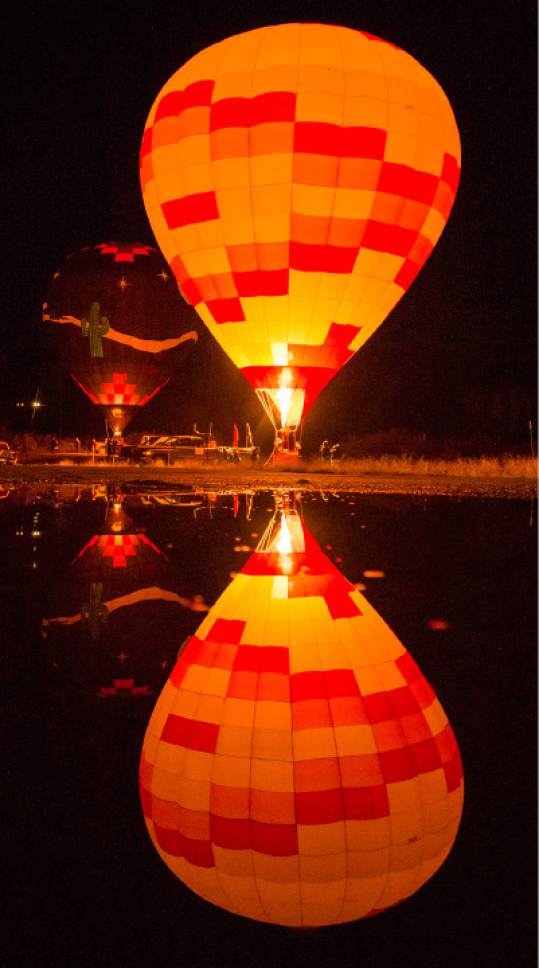 Rick Egan  |  The Salt Lake Tribune

The "Marauders' Mark" from Albuquerque reflects in a puddle, during the glow-in at the Bluff Balloon Festival, Saturday, January 14, 2017.