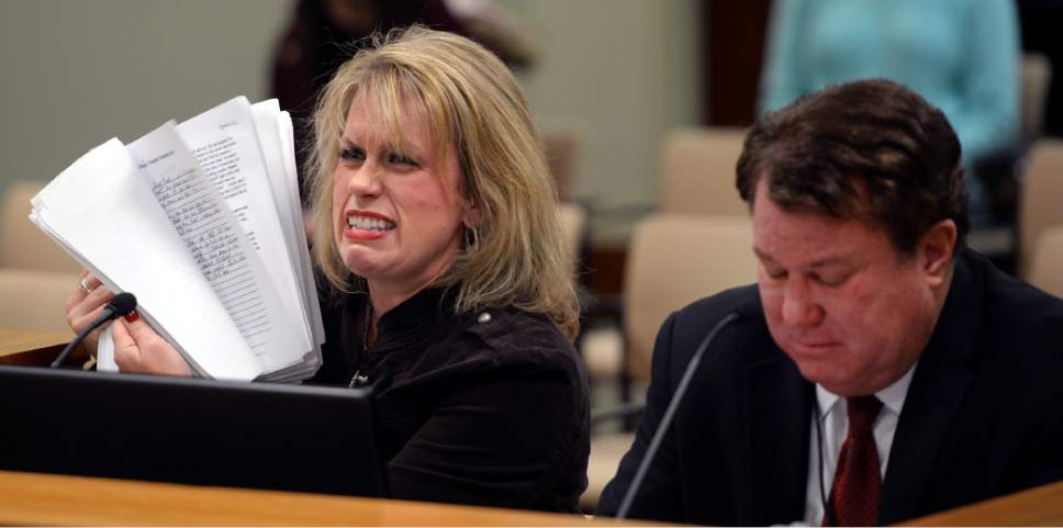 Steve Griffin  |  The Salt Lake Tribune
Holding a stack of her court and police documents Heather Wolsey, a victim of domestic violence in 2012, cries as she sits with Rep. LaVar Christensen, R-Draper, and tells members of the House Judiciary Standing Committee about her ongoing ordeal with protective orders in the House Building at the State Capitol in Salt Lake City on Thursday. HB248 is designed to creating a domestic violence continuous protective order for victims of domestic violence.