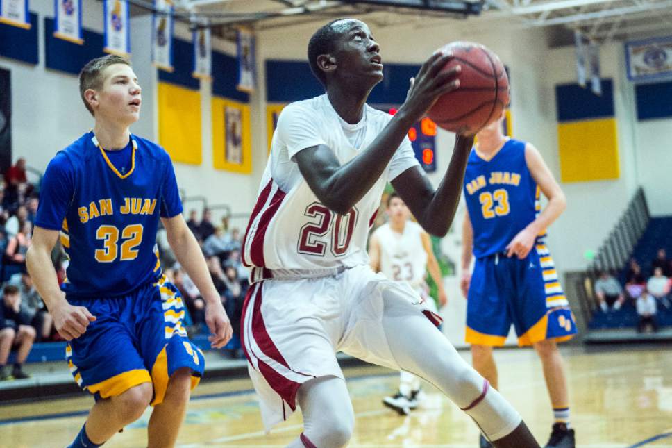 Chris Detrick  |  The Salt Lake Tribune
Layton Christian Sano Gasana (20) shoots past San Juan Ramsay Holliday (32) during the 2A play-off game at Orem High School Saturday February 18, 2017. Layton Christian defeated San Juan 81-63.