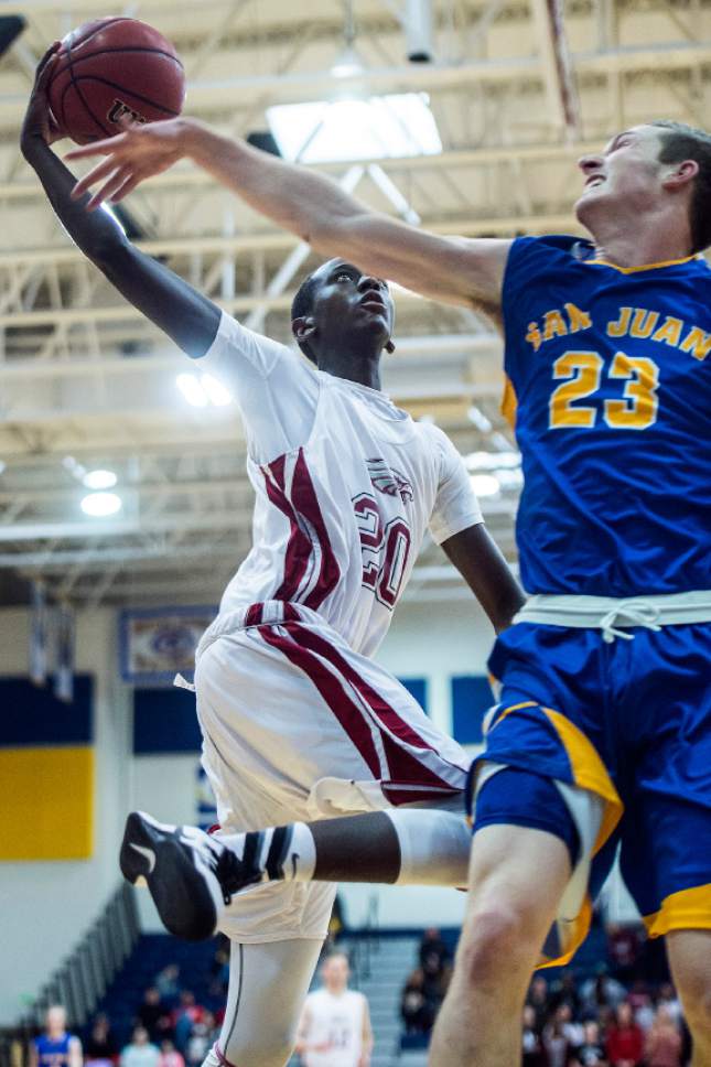 Chris Detrick  |  The Salt Lake Tribune
Layton Christian Sano Gasana (20) shoots past San Juan Jordan Blake (23) during the 2A play-off game at Orem High School Saturday February 18, 2017. Layton Christian defeated San Juan 81-63.