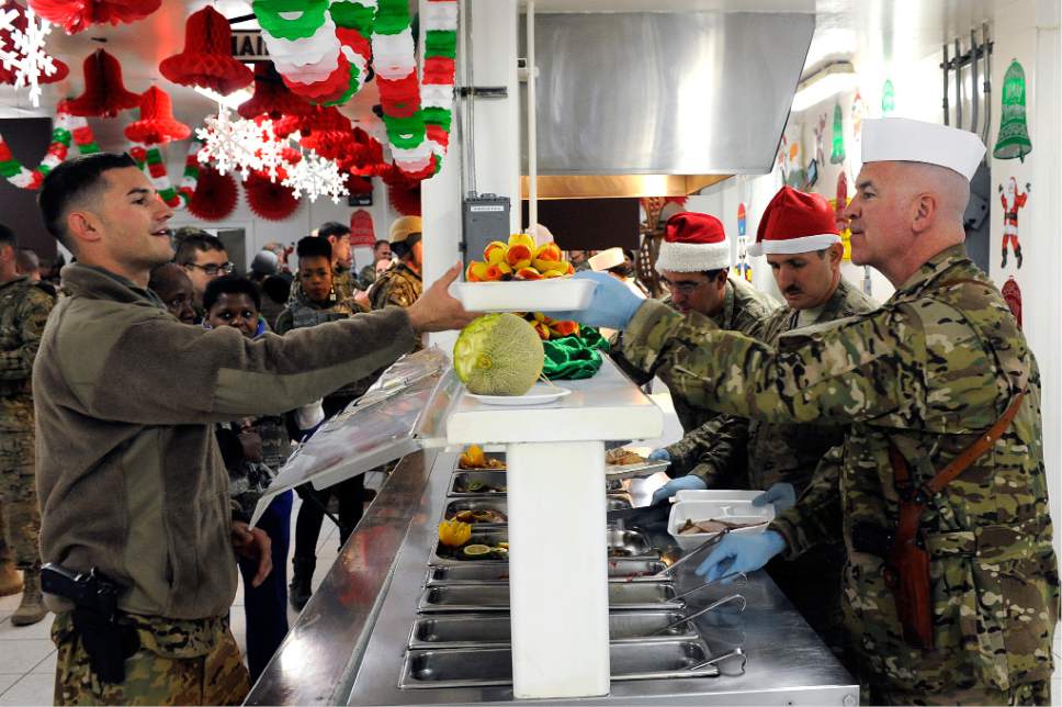 Senior Airman Chris Willis  |  U.S. Air Force

Col. Timothy Hogan, 455th Air Expeditionary Wing vice commander, Chief Master Sgt. Lawrence Bucher, 455th Expeditionary Aircraft Maintenance Squadron, and 455th AEW Command Chief Master Sgt. Steven Bohannon, serve Airmen turkey and other dishes during a Christmas Day celebration at Bragram Airfield, Afghanistan, Dec. 25, 2012. Squadron and wing leadership served meals throughout the holidays to boost the morale of the servicemen and women.
