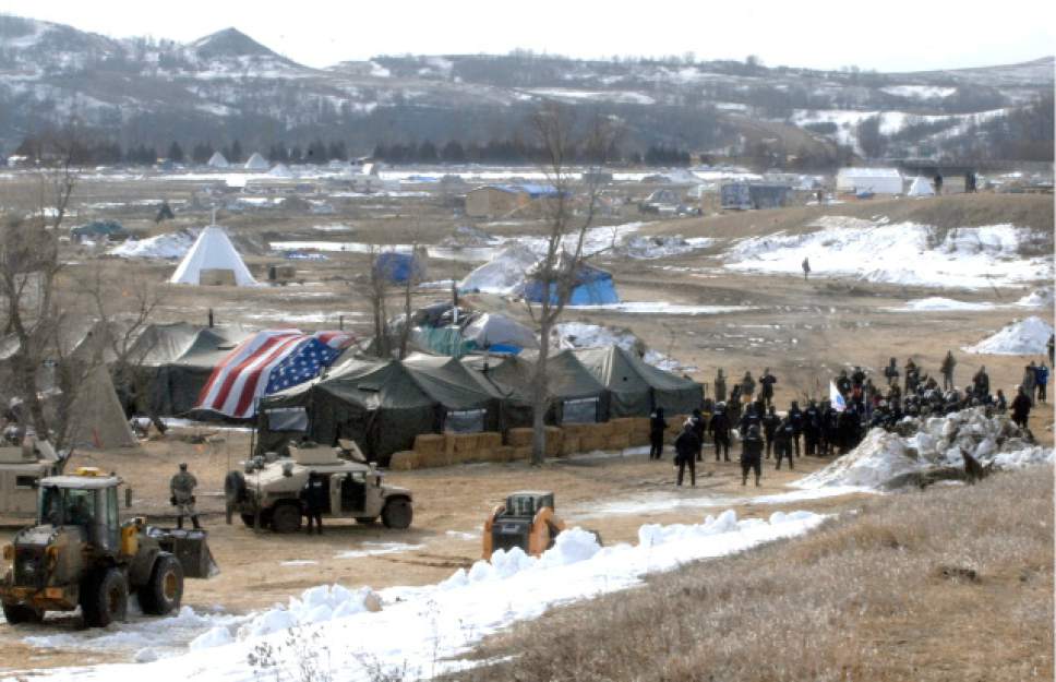 Law enforcement enters the Oceti Sakowin camp to begin arresting Dakota Access Pipeline protesters  in Morton County, Thursday, Feb. 23, 2017, near Cannon Ball, N.D. As the arrests were underway law enforcement personnel drove several large construction equipment into the camp to begin the cleanup process of razing tents and structures.  (Mike McCleary/The Bismarck Tribune via AP, Pool)
