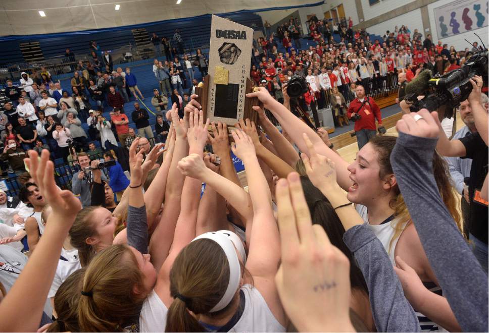Scott Sommerdorf | The Salt Lake Tribune 
Skyline players reach for the trophy after it was delivered to the floor. Skyline defeated Judge Memorial 60-57 in OT to take the Girl's 4A championship, Saturday, February 25, 2017.