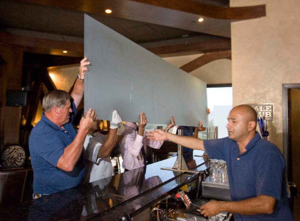 Paul Fraughton  |  Tribune file photo

Moshen Asgari, right, supervises the removal of the "Zion curtain" from the bar at his Vuda Bar and Winery in Draper. A new poll says that most Utahns would like to do away with the so-called "Zion Curtains."