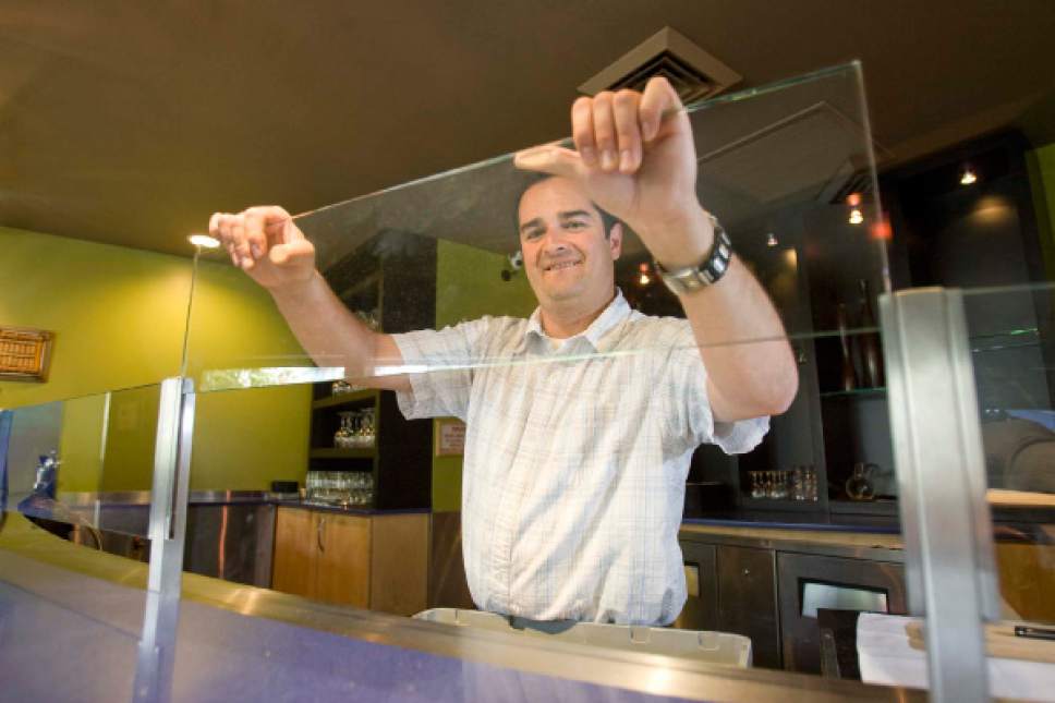 Paul Fraughton/ The Salt Lake Tribune

Shawn Boyle, the general manager of Faustina restaurant, demonstrates Monday how easily the "Zion Curtain" can be removed from  the restaurant's bar area. Starting at midnight Monday, restaurants no longer are required to erect the barriers, which under old laws separated diners from alcoholic beverages.