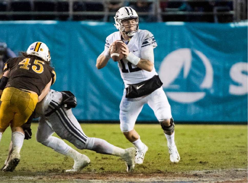 Rick Egan  |  The Salt Lake Tribune

Brigham Young Cougars quarterback Tanner Mangum (12) looks for an open man, in the Poinsettia Bowl, at Qualcomm Stadium in San Diego, December 21, 2016.