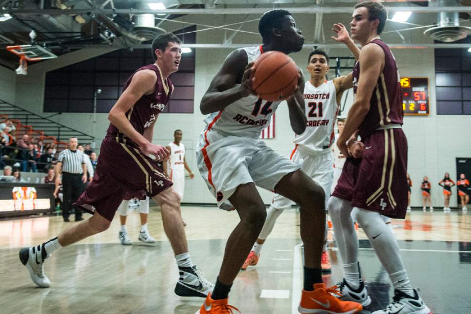 Chris Detrick  |  The Salt Lake Tribune
Wasatch Academy's Emmanuel Akot (14) charges Lone Peak's Nate Harkness (35) during the game at Wasatch Academy Thursday December 10, 2015.  Lone Peak won the game 68-65.