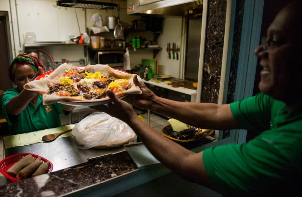 Rick Egan  |  The Salt Lake Tribune

Haregewine Yohanis hands a plate of food to Sleshi Tadesse at the Mahider Ethiopian Restaurant in Salt Lake City on Friday, Feb. 17, 2017.