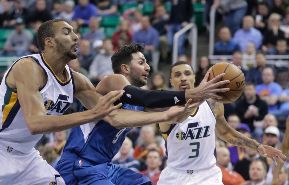 Minnesota Timberwolves guard Ricky Rubio (9) battles with Utah Jazz's Rudy Gobert, left, and George Hill (3) for a loose ball during the first half in an NBA basketball game Wednesday, March 1, 2017, in Salt Lake City. (AP Photo/Rick Bowmer)