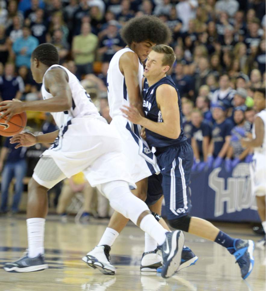 Steve Griffin  |  The Salt Lake Tribune

Brigham Young Cougars guard Kyle Collinsworth (5) runs into a Utah State Aggies guard Jalen Moore (14) as he sets a pick during first half action in the BYU versus USU men's basketball game in Logan, Tuesday, December 2, 2014.