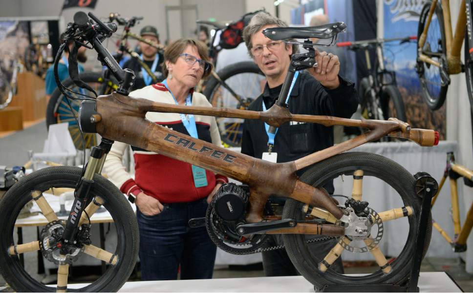 Al Hartmann  |  The Salt Lake Tribune
Debra Banks, a hand crafted saddle manufacturer for Rivet Cycle Works, left, checks out a one of a kind "Big Bamboo Bike" made by Craig Calfee of Calfee Designs out of Santa Cruz, CA. at the 2017 North American Handmade Bicycle Show at the Salt Palace Convention Center on Friday.  This model is an electric bike made of a bamboo including the wheel spokes. The battery is inside the large tube. He makes several more coventional design custom bicycles using bamboo frames.  
It's the largest and oldest handbuilt bicycle show in the world where ideas and innovation come together to promote custom bicycles and the companies that support the market. It is the show's first time in Utah. The event runs through Sunday.