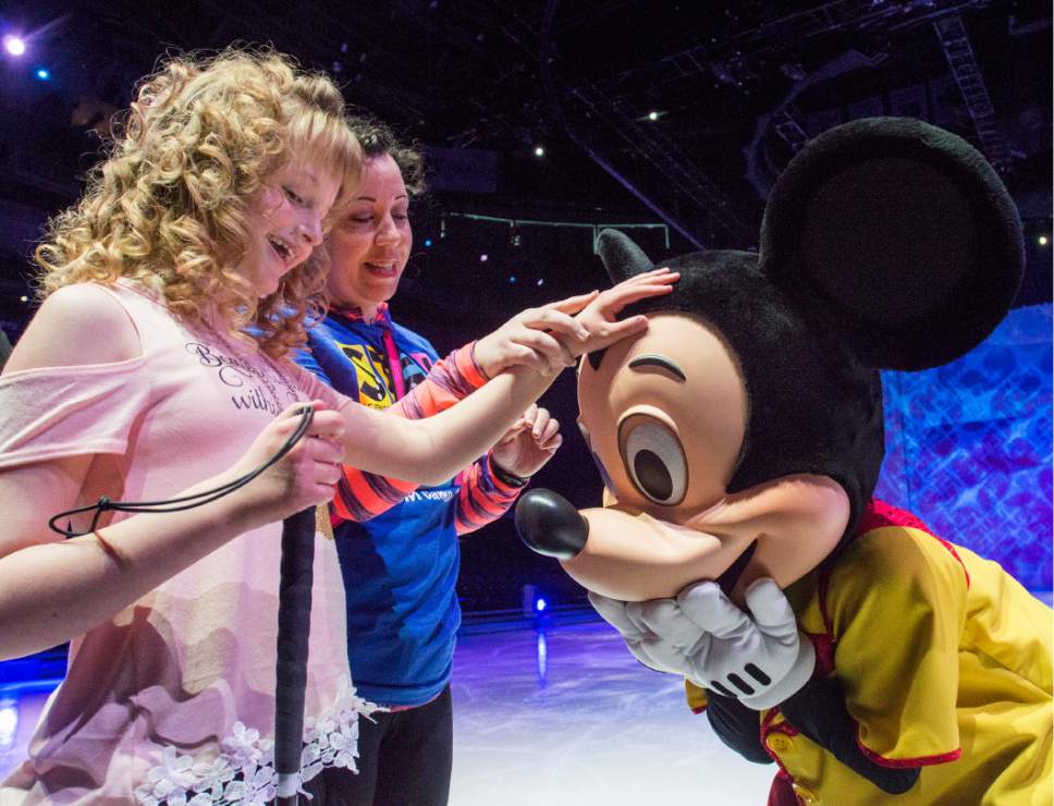 Rick Egan  |  The Salt Lake Tribune
Robbin Clark assists Kiyrah Miller as she touches Mickey Mouse, during a special sensory touch tour for visually-impaired students from Utah Schools for the Deaf and Blind, hosted by Disney On Ice, at Vivint Smart Home Arena on Friday.