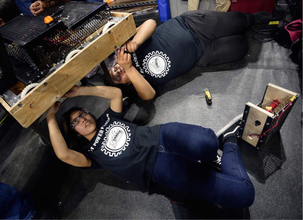 Scott Sommerdorf | The Salt Lake Tribune
Nahida Smith, left, and Fredale Burns work underneath the robot to remove the wooden bumpers to allow for new ones to be installed. The Navajo Mountain High School robotics team competes at the "Utah FIRST Robotics Competition," Thursday, March 9, 2017.