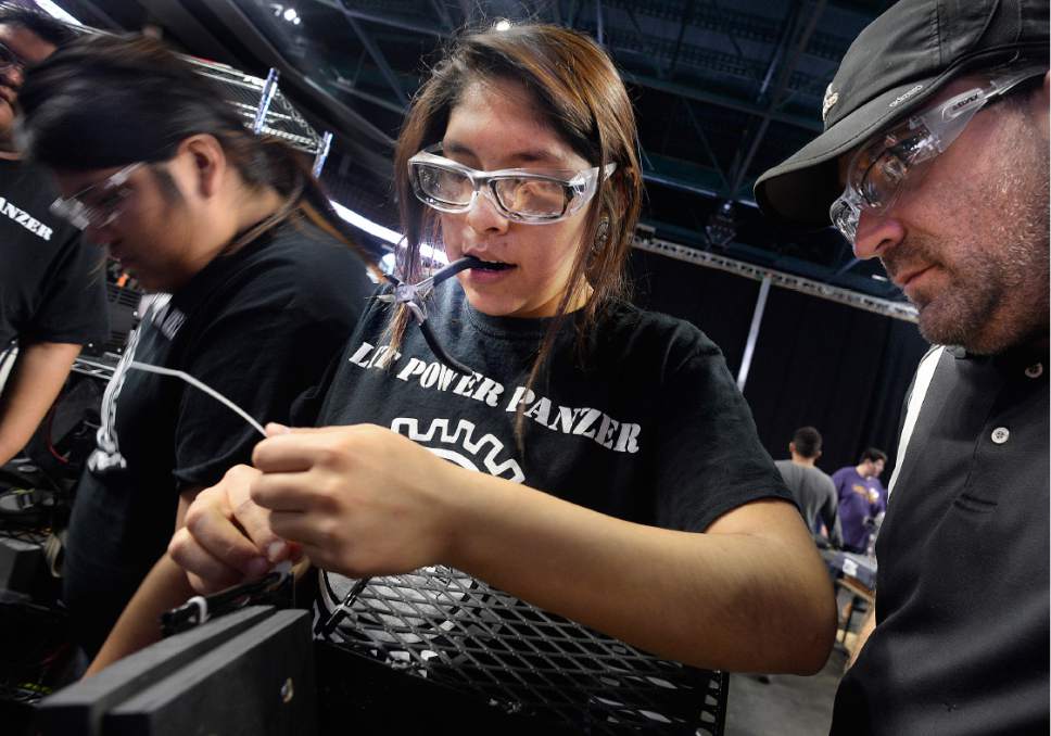 Scott Sommerdorf  |  The Salt Lake Tribune
Nahida Smith works on attaching zip ties to the robot as mentor and science teacher Daniel Conrad watches at right. The Navajo Mountain High School robotics team won  the Rookie All Star Award at the Idaho Regional FIRST Robotics Competition, qualifying to be in the championship competition.